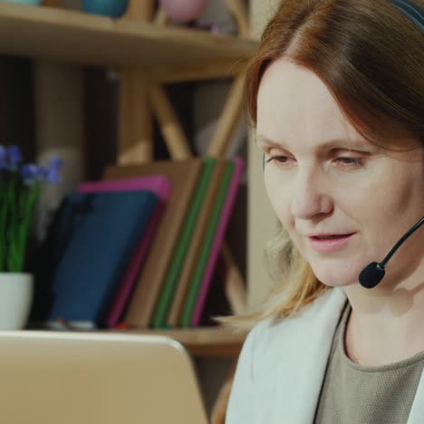 the woman communicates with customers from home by speaking into the headset 1