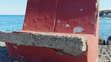banco de piedra grunge en la playa con pintura roja saliendo