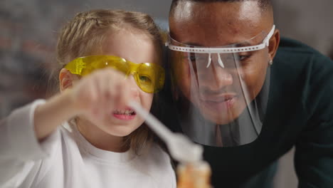 funny brave girl adds catalyst powder into bottle near tutor