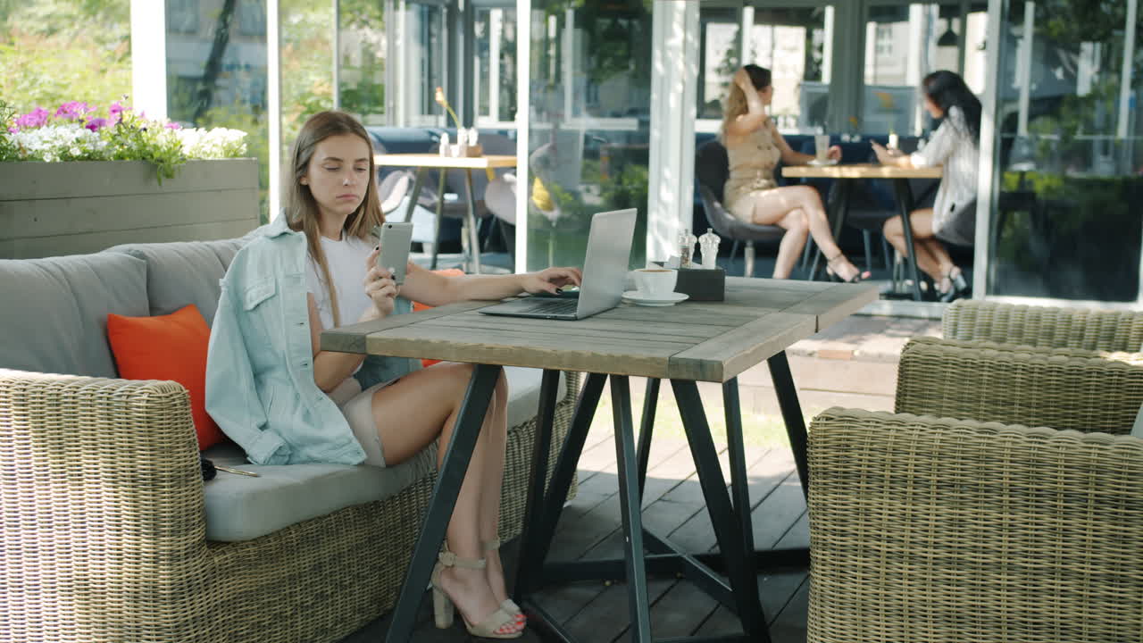 mujer trabajando en una computadora portátil en un café al aire libre