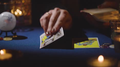 primer plano de una mujer dando una lectura de cartas de tarot en la mesa a la luz de las velas 12