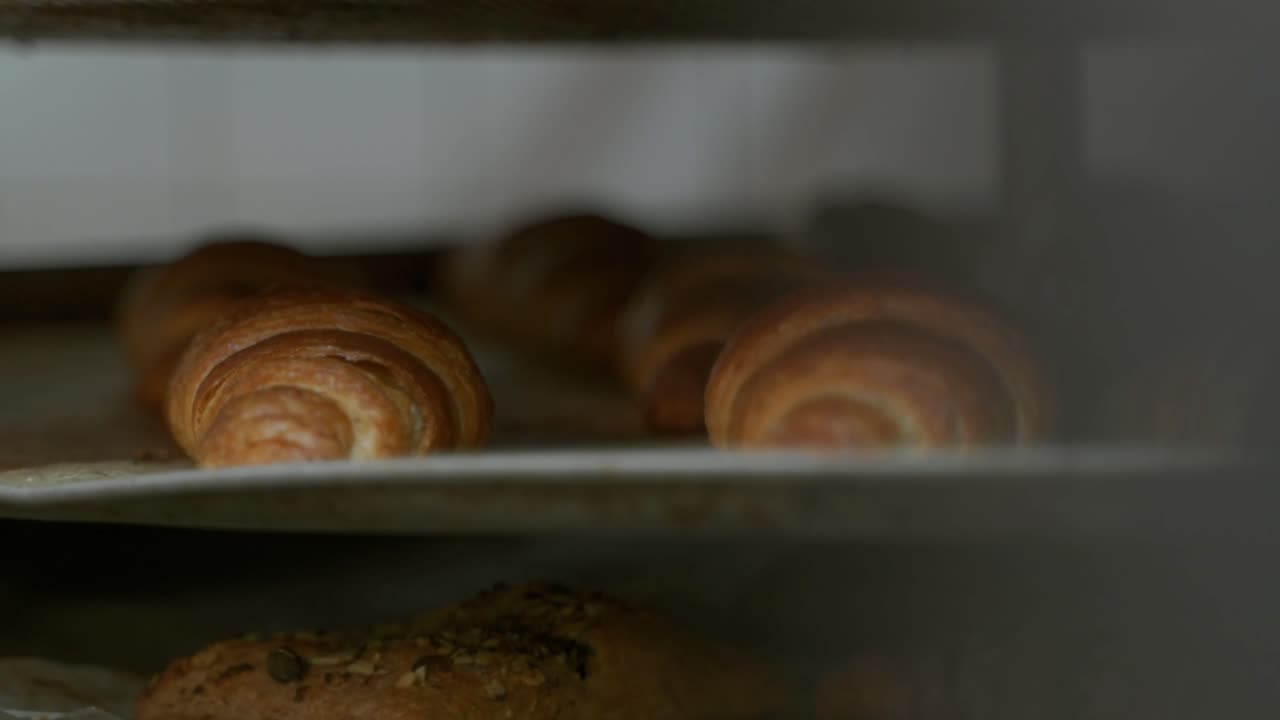 Croissanter på en bageplade i et bageri, fisk bagt gyldenbrun og lækker.