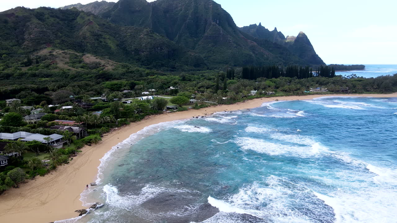 Aerial Zoom Toward Haena on Clear Day as Waves Roll In