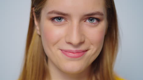 Closeup-smiling-attractive-woman-looking-at-camera-on-grey-background.