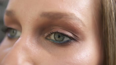 disparo en primer plano de una mujer abriendo sus ojos verdes con maquillaje de día claro y enfocándolos. mujer joven hermosa atractiva abre
