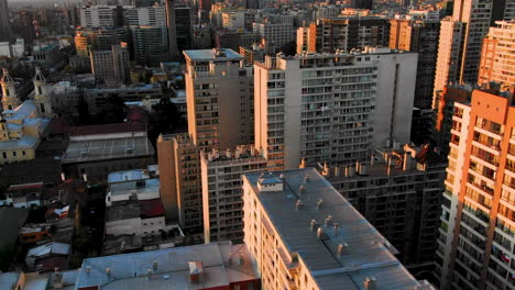 Drone-captures-bustling-Santiago-streets-at-twilight,-showcasing-urban-movement-and-city-light