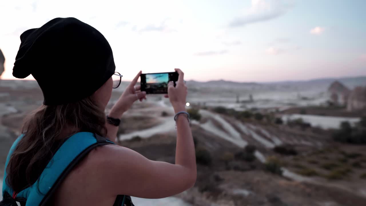 Mujer fotografiando las Chimeneas de Hadas en Capadocia con un smartphone