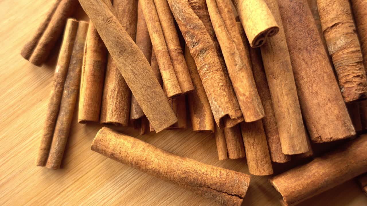 Paus de canela girando ao fundo, com um close-up de especiarias