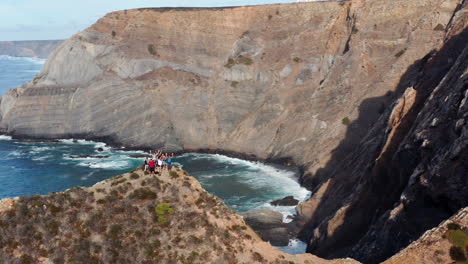 Aerial-orbiting-shot-showing-group-of-hiker-waving-hands-after-reaching-peak-of-mountain