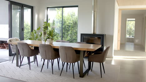 a modern dining room with wooden table and chairs, a fireplace warming space