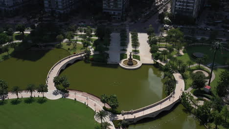 aerial-view-of-a-beautifully-landscaped-park-on-a-clear-sunny-day-with-colorful-children's-playground-tennis-courts-and-putting-green