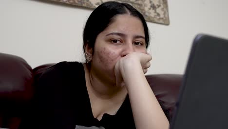 un adolescente concentrado navegando en una tableta en casa, pareciendo reflexivo y absorto