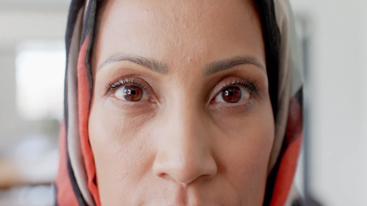 retrato de una feliz mujer de negocios biracial con hijab en la oficina en cámara lenta