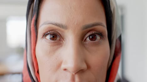 retrato de una feliz mujer de negocios biracial con hijab en la oficina en cámara lenta