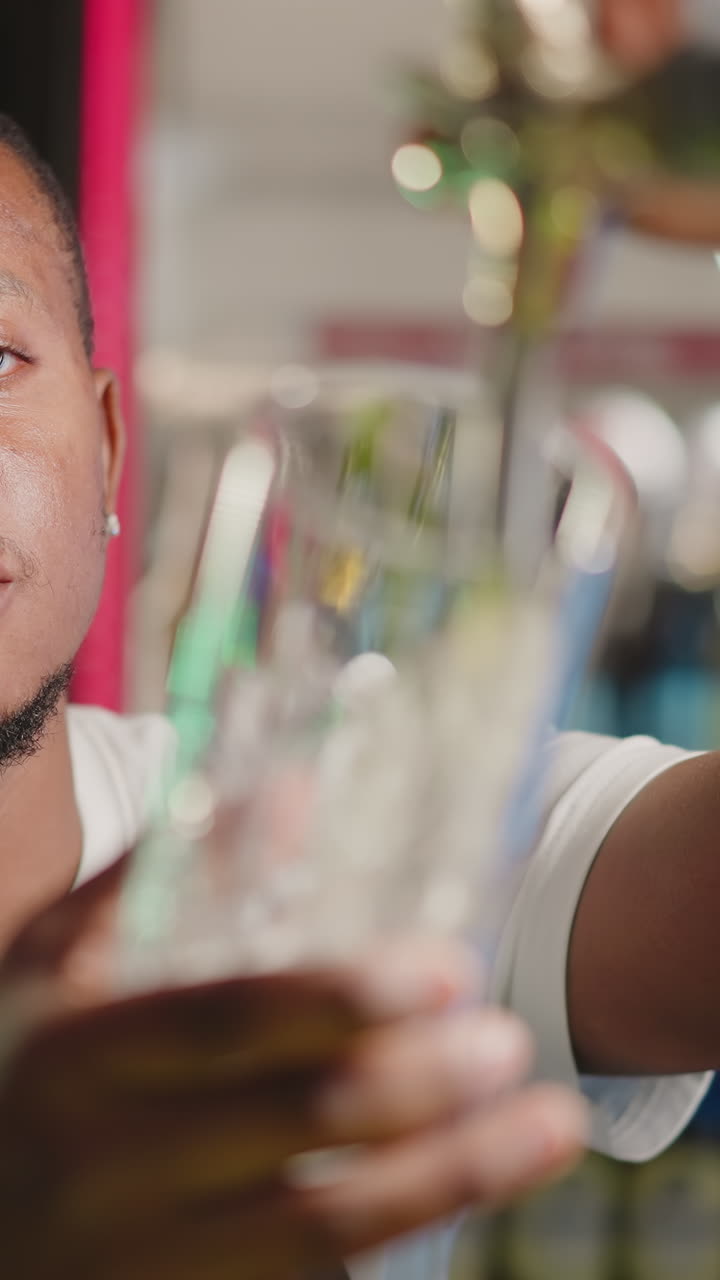 술집에서 맥주 한 잔을  채우는 술집 직원. 심각한 아프리카계 미국인 술집 주인이 카운터에서 일하는 컵에 맥주를 는다. 흑인 남자가 음료를 제공한다.