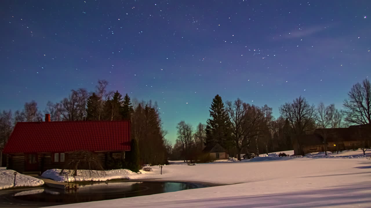 toma de tiempo de casas de pueblo cubiertas de nieve con la vista de luces polares o aurora en el fondo por la noche