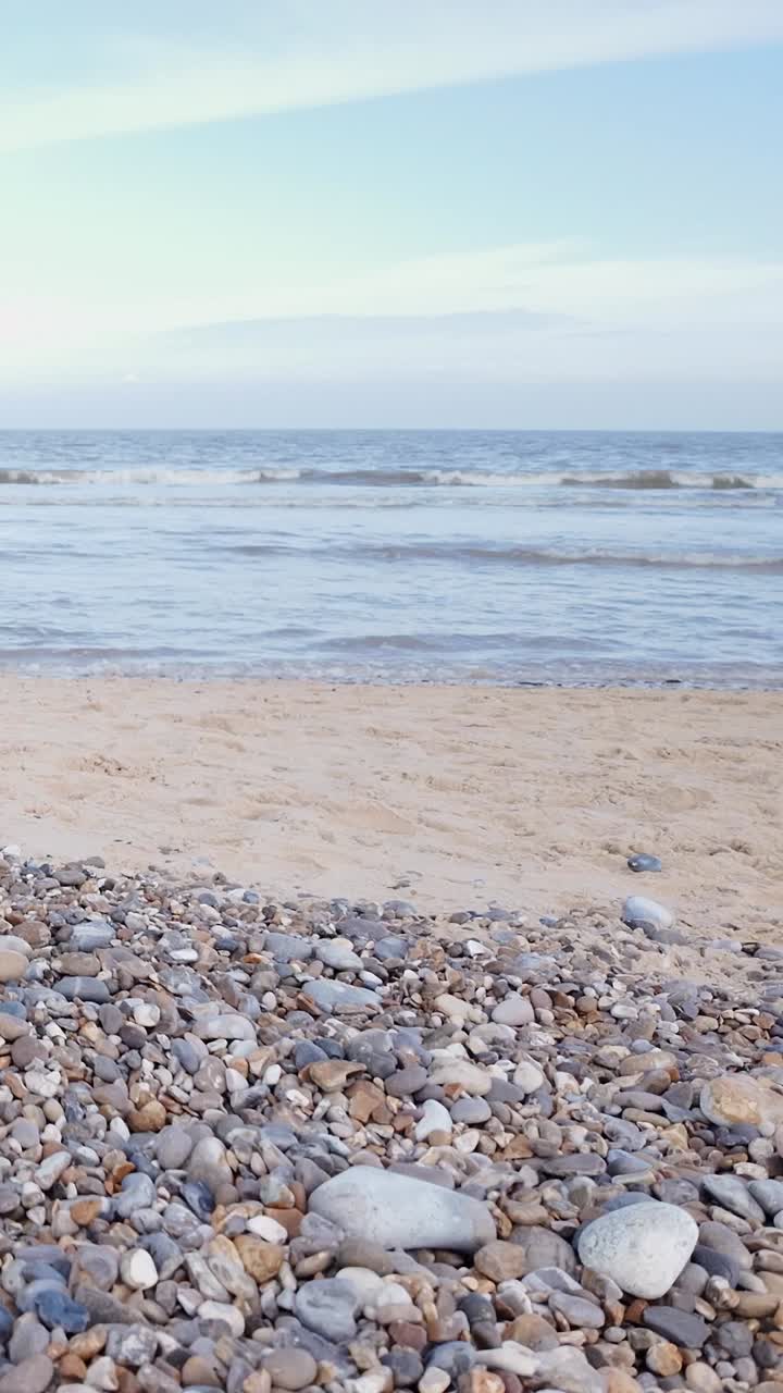 Seaside setting background with sandy pebble beach VERTICAL shot