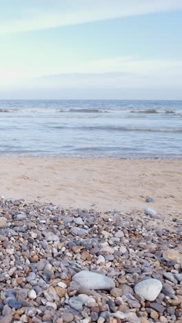 seaside setting background with sandy pebble beach vertical shot