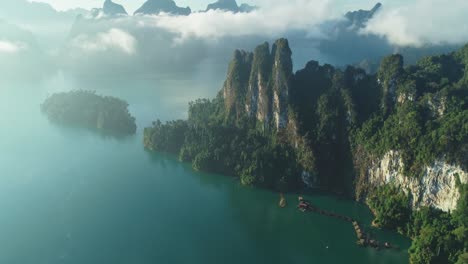 an aerial view shows green mountains and harbor lodgings among the clouds at khao sok national park in surat thani thailand 1