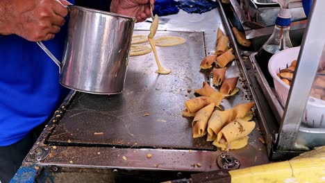 link ×title: merchant making street food to do thai dessert , pancake roll with pork, sausage, egg filling, sweet