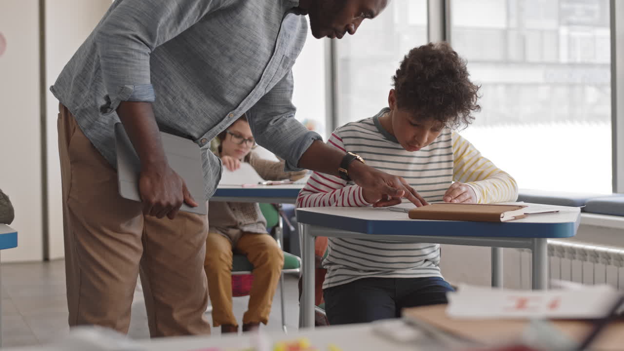 School Teacher Helping Children during Test