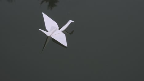 closeup of origami swan floating on water surface