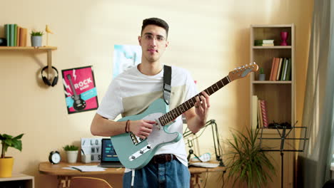 young man practising with the guitar