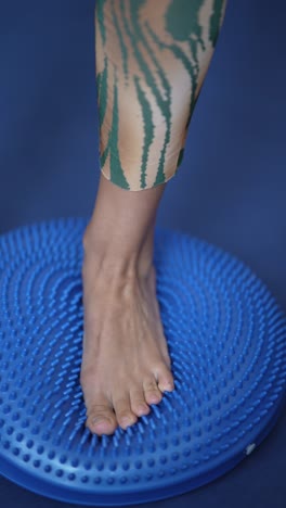 person balancing on a blue balance disc