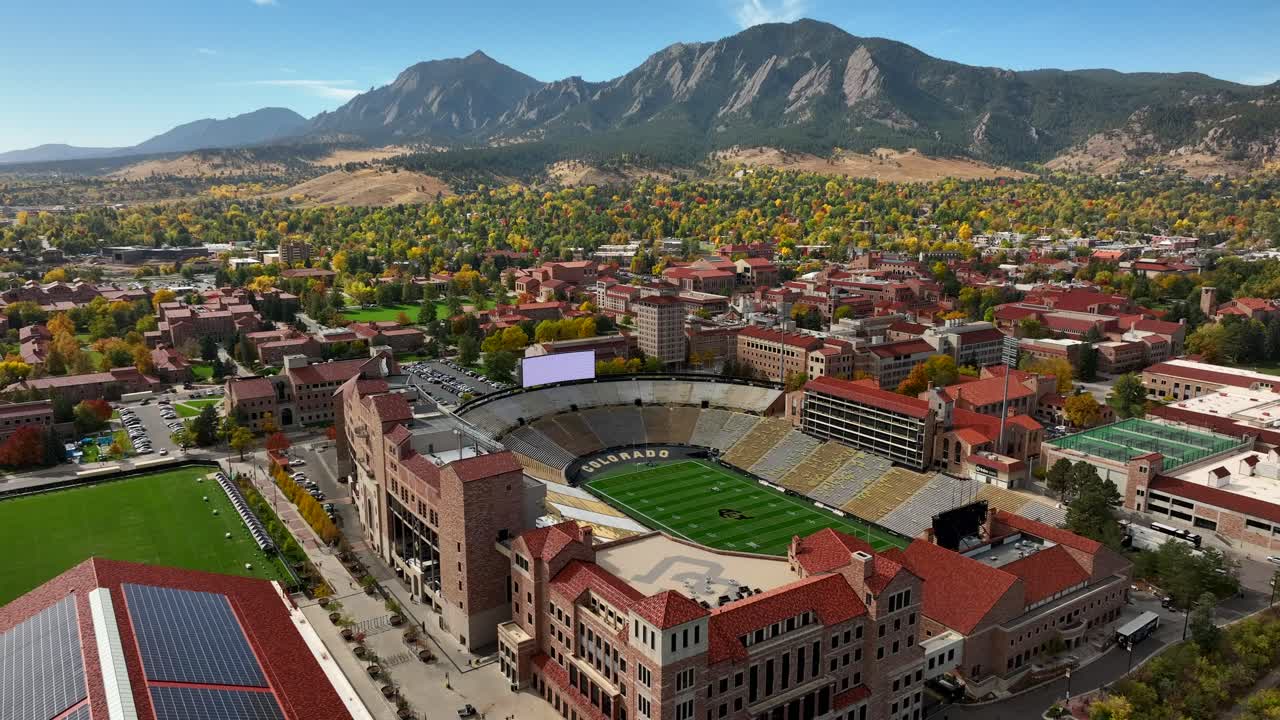 Aerial Reverse over Folsom Field Football stadium in Boulder, Colorado at the University of Colorado on a clear fall day