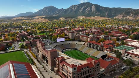 aerial reverse over folsom field football stadium in boulder, colorado at the university of colorado on a clear fall day