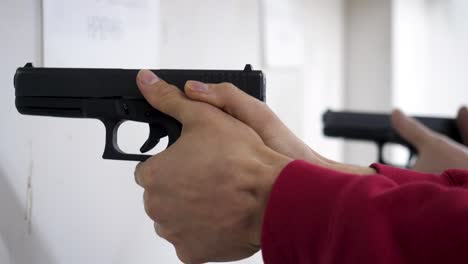 people practicing with handguns at a shooting range.