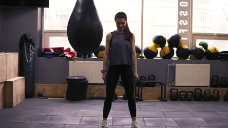 frontside footage of a brunette young female workouter in her 20's performing squats. fitness and wellbeing.