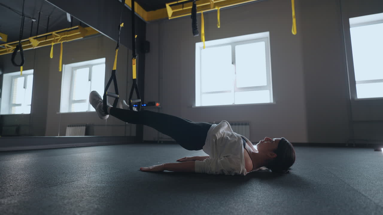 mujer deportiva haciendo ejercicios de trx en el gimnasio. mujeres entrenando con correas de fitness en el gimnasio. mujer hermosa ejercitando sus músculos con correa o correas de suspensión.