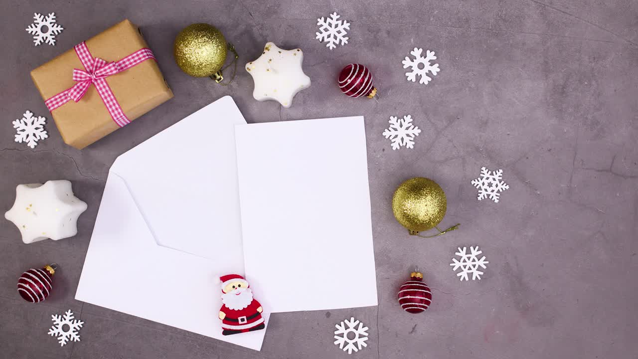 Regalo de Navidad, velas y adornos se mueven alrededor de un papel en un sobre para texto. Stop motion