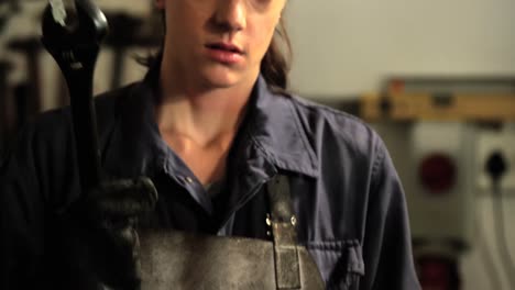 female welder holding wrench tool