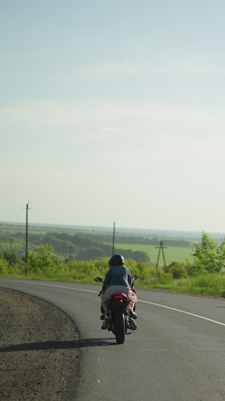 여동생들이 길에서 구부러지는 동안 천천히 전력 자전거를 타고, 반대 방향에서 오는 자동차의 흐릿한 시각, 나무와 풍경 풍경이 배경입니다.