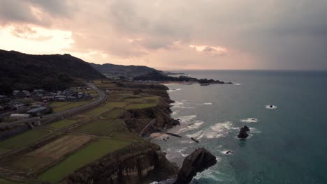 Luftaufnahme-Von-Sonnenuntergang-Am-Strand-Mit-Klippenlandschaft-In-Kyotango,-Kyoto,-Meer,-Reisedorf,-Japan,-Rosa-Himmel-Im-Reiseziel