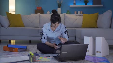 Home-office-worker-woman-gets-frustrated-while-looking-at-phone.