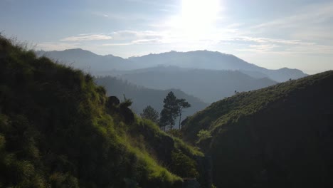 Beautiful-aerial-drone-forward-moving-shot-flying-through-mountain-range-along-Little-Adam's-Peak-hill--the-popular-destination-in-Ella-town,-Sri-Lanka-at-sunrise