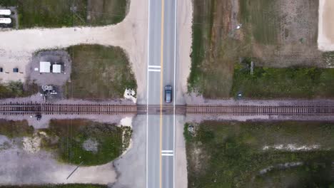 Vehicle-driving-on-a-highway-in-the-summer-and-crosses-a-railroad