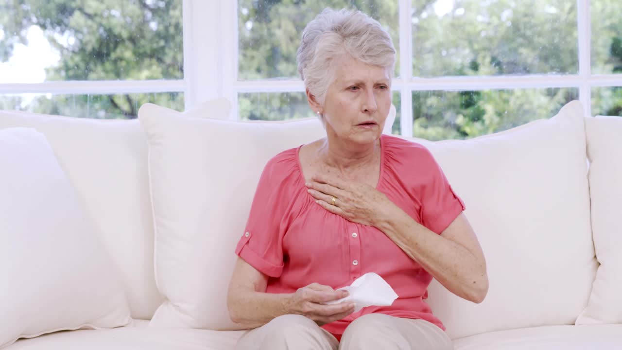 mujer mayor llorando en el sofá