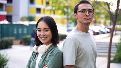 outdoor portrait of two japanese friends smiling and looking at camera in the street 1