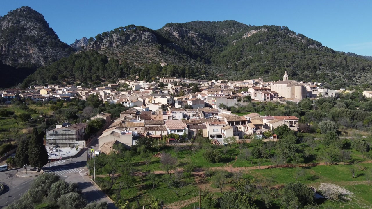 Aerial approach to the village of Caimari, with the Tramuntana mountain range in the background. Mallorca, Spain.