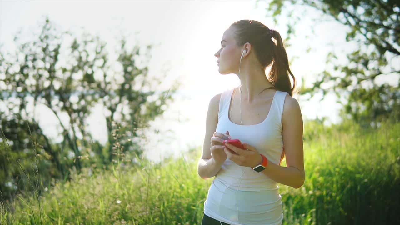 야외 에서 운동 하는 동안 음악 을 듣고 있는 여자