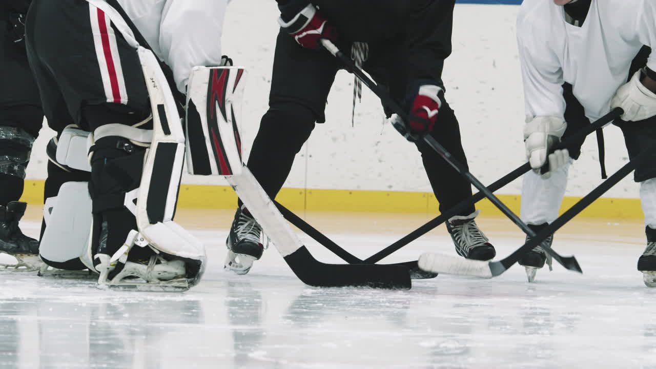 Male Hockey Players Tapping Sticks On Ice Before Game