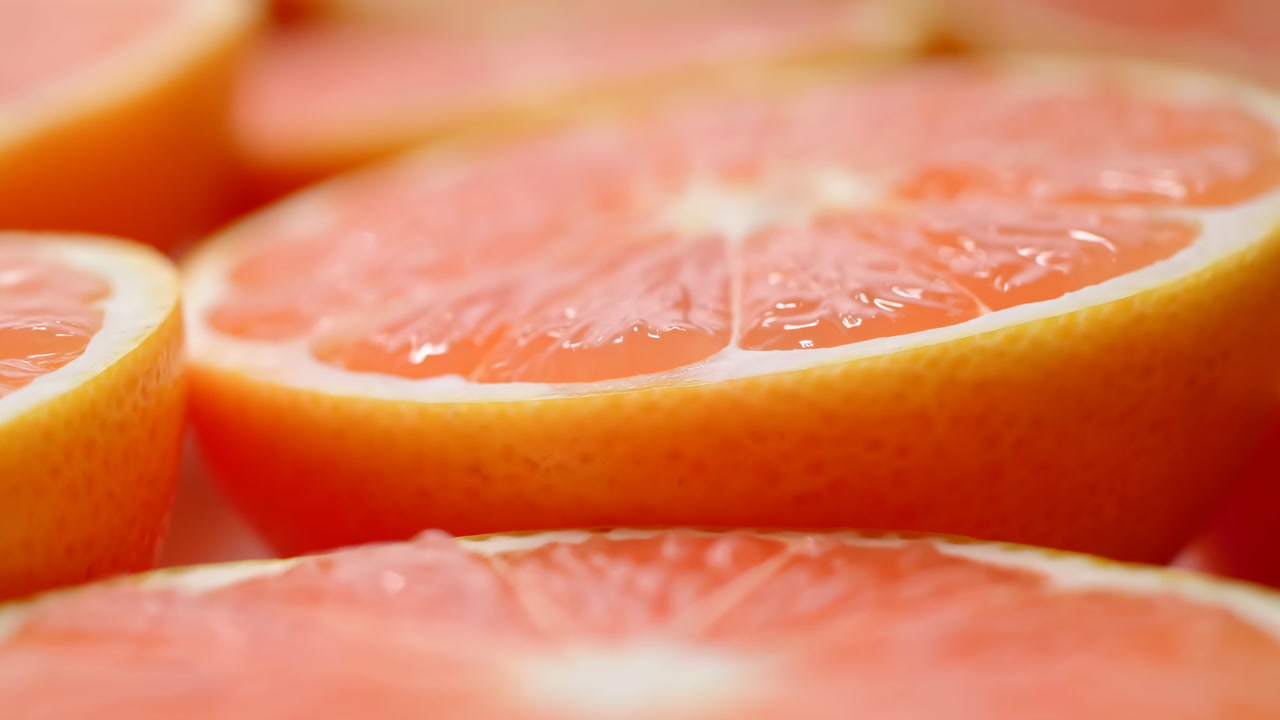 Closeup Pink Grapefruit Halves Glistening With Juice, Sunlit Shallow Focus Revealing Translucent Pulp