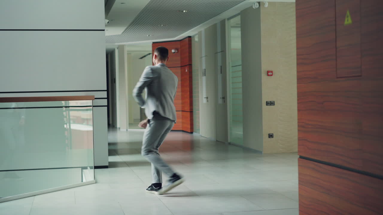 Businessman Dancing in Office Corridor
