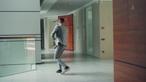 businessman dancing in office corridor