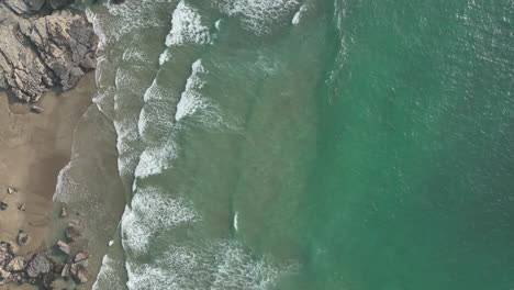 Trebarwith-beach,-Cornwall,-aerial-flight-looking-down-to-beach-and-waves---mavic-3-cine-prores-422---Clip-4