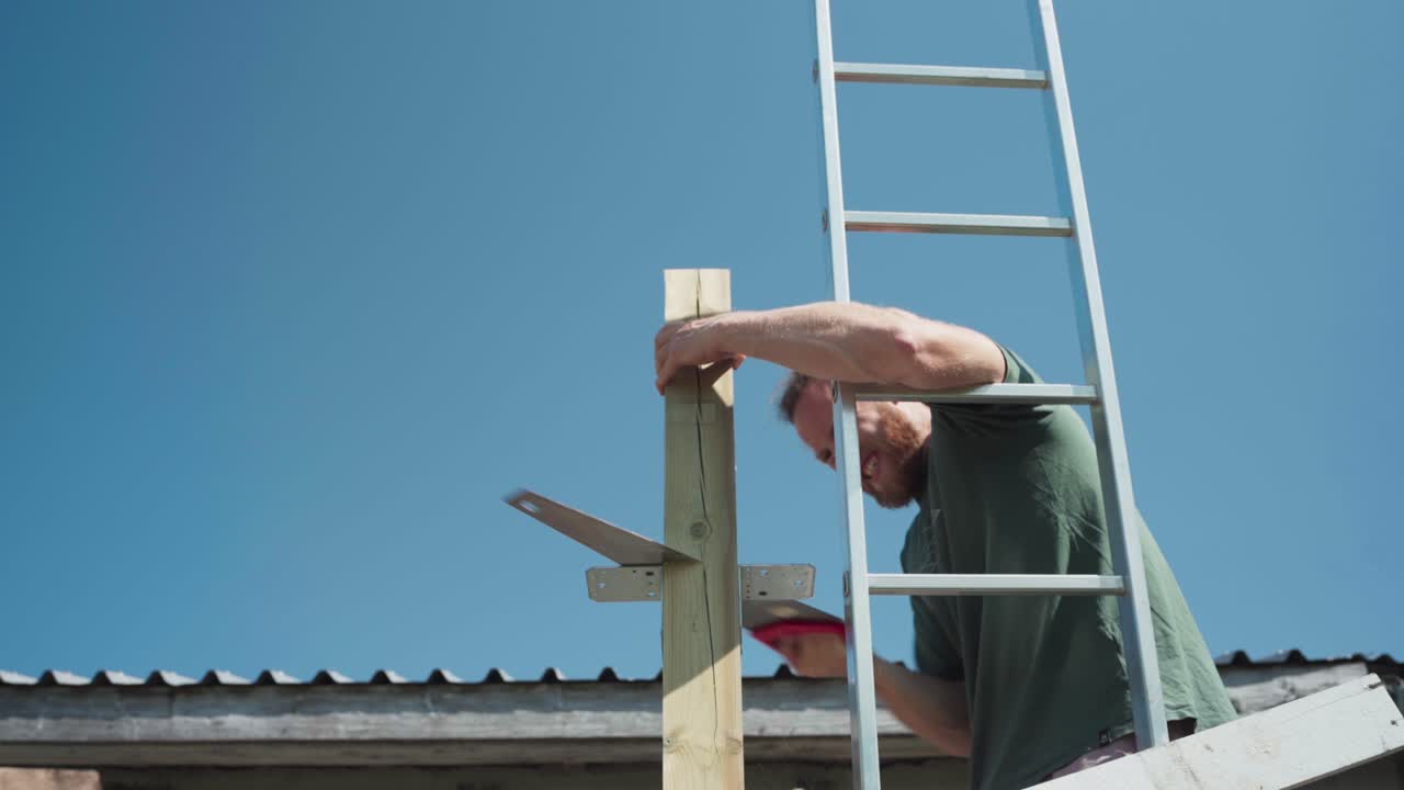 Portrait Of A Man Sawing Wooden Block Frame During Sunny Day